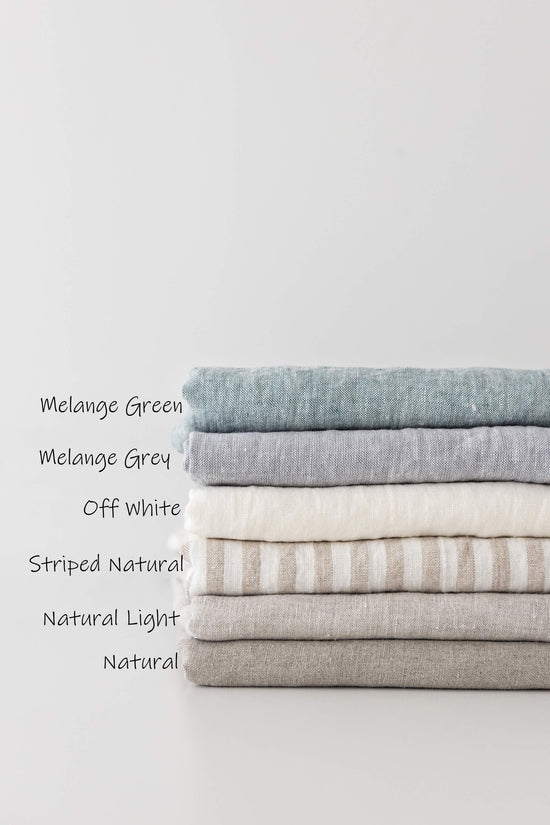 a stack of folded linens labeled with names