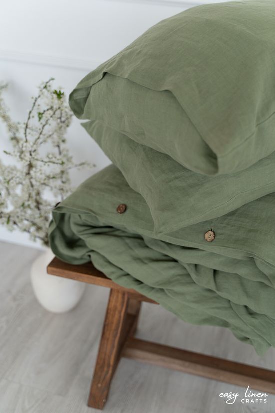 a stack of blankets sitting on top of a wooden bench